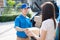 Delivery service male in uniform give cardboard box package to receiver customer client front home