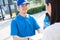 Delivery service male in uniform give cardboard box package to receiver customer client front home