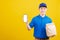 Delivery service man smiling wearing blue uniform hold paper containers for takeaway bag grocery food packet and show smartphone