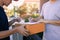 Delivery young man standing at the door of home and carrying parcels for young male to signing