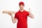 Deliveryman 25y in red t-shirt and cap holding takeaway box with