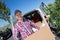 Deliveryman carrying cardboard parcel box in front delivery