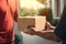 Deliveryman deliver a package box to the customer focus on their hands