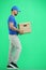 The deliveryman, full-length, on a green background, with a box