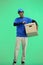 The deliveryman, full-length, on a green background, with a box