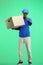 The deliveryman, full-length, on a green background, with a box