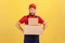 Deliveryman holding two heavy big cardboard boxes in hands, having funny facial expression.