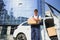 Deliveryman holds parcels at the car, delivering