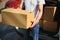 Deliveryman holds parcels at the car, delivering