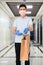 Deliveryman in medical mask and protective gloves holding paper bag. Contactless safe home delivery during quarantine