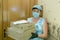 A deliverywoman. A middle-aged woman brought pizza home to a customer. The deliveryman`s work in the conditions of coronavirus