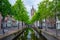 Delt canal with bicycles and cars parked along. Delft, Netherlands