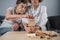 Dementia therapy in playful way, training fingers and fine motor skills, build wooden blocks into tower, playing Jenga. Senior