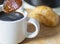 Demerara sugar in a silver teaspoon, absorbing hot espresso coffee from a small cup,in a domestic kitchen,Worcestershire,United