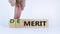 Demerit or merit symbol. Businessman turns wooden cubes and changes words `demerit` to `merit`. Beautiful white background, co