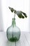 Demijohn vase with tropical leaf. Decoration glass vase.