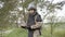 Demining. Male sapper carefully carries an anti-tank mine in his hands near the forest and looking at camera