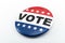 Democracy, presidential election and voting poll concept with red, white and blue vote glossy button pin with stars and stripes
