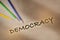 Democracy written on brown paper background with color pencil