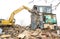 Demolishing a building with a large backhoe