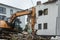 Demolition of a building. An excavator breaks an old house.