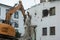 Demolition of a building. An excavator breaks an old house