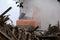 Demolition of the building with the help of technology, dust and trees around the wreckage of the building under the wheels