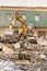 Demolition house using excavator in city. Rebuilding process. Remove equipment