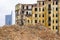 Demolition of a large old historic stone house in the city, new multi-storey buildings in the background