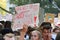 Demonstration during Global Climate Strike with damaged paper sign being held up saying `Our world is as screwed as this sign` in