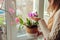 Dendrobium orchid and bougainvillea. Woman taking care of home plats. Woman holding pot in basket with flowers