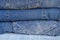 Denim background. Neat stack of various shades of blue jeans. Clothes storage