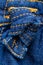 Denim decoration background. Close-up of a blue jeans knot or node at kids skirt as a decoration element. Macro