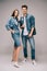 Denim dress with hand in pocket and smiling boyfriend in jeans and shirt looking at camera