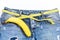 Denim pants with banana imitating male genitals on white background