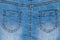 Denim pockets texture. Close-up of back view of details of a light blue fabric jean surface of a skirt. Macro. Top view. Beautiful