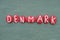 Denmark, Scandinavian country, souvenir composed with red colored stone letters over green sand