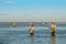 DENPASAR, INDONESIA - May 24 Traditional Balinese fishermen standing in shallow water at low tide on the beach at Nusa Dua, Denpas