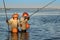 DENPASAR, INDONESIA - May 24 Traditional Balinese fishermen standing in shallow water at low tide on the beach at Nusa Dua, Denpas