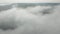 Dense Clouds Canopy Over Foggy Forest Mountains. Aerial Shot