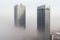 Dense dense fog cloud over high-rise office buildings, architecture in a smoky effect. AI generated.