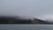 A dense fog envelops the rocks near the water. Andreev.