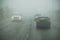 Dense fog and poor visibility on the road. Dangerous driving situations. View on highway traffic. Misty morning. Low visibility.