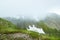 Dense fog roofed tops of snow peaks, reducing visibility. Rain clouds over mountain valley