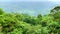 Dense green rainforests high in the mountains, a view of the settlement, the foot of the mountains, fog covers the