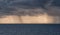 Dense rain clouds and a tornado over the sea