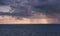 Dense rain clouds and a tornado over the sea