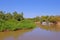 Densely forested shores of the Aquidauana river in the brazilian Pantanal, houseboats on the riverbank, Brazil