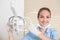 Dental assistant smiling at camera beside light