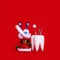 Dental Care Dentist Merry Christmas Card Tooth Model Santa`s shoe With Presents And Dental Instruments On Red Background With Copy